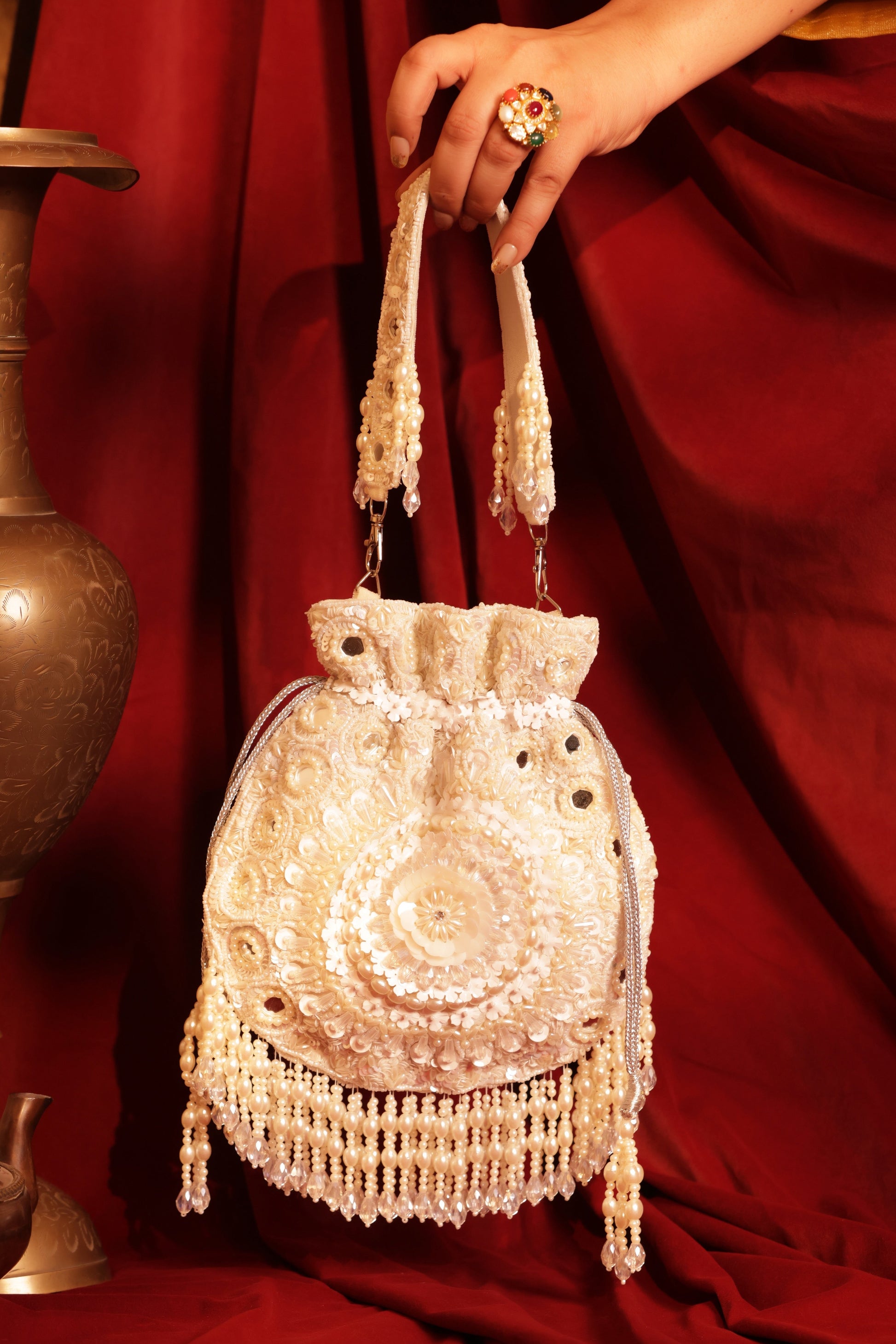Noor E Gulzar white suede potli bag with pearl and sequin embellishments, ideal for weddings, sangeet, and festive celebrations with lehengas and sarees.
