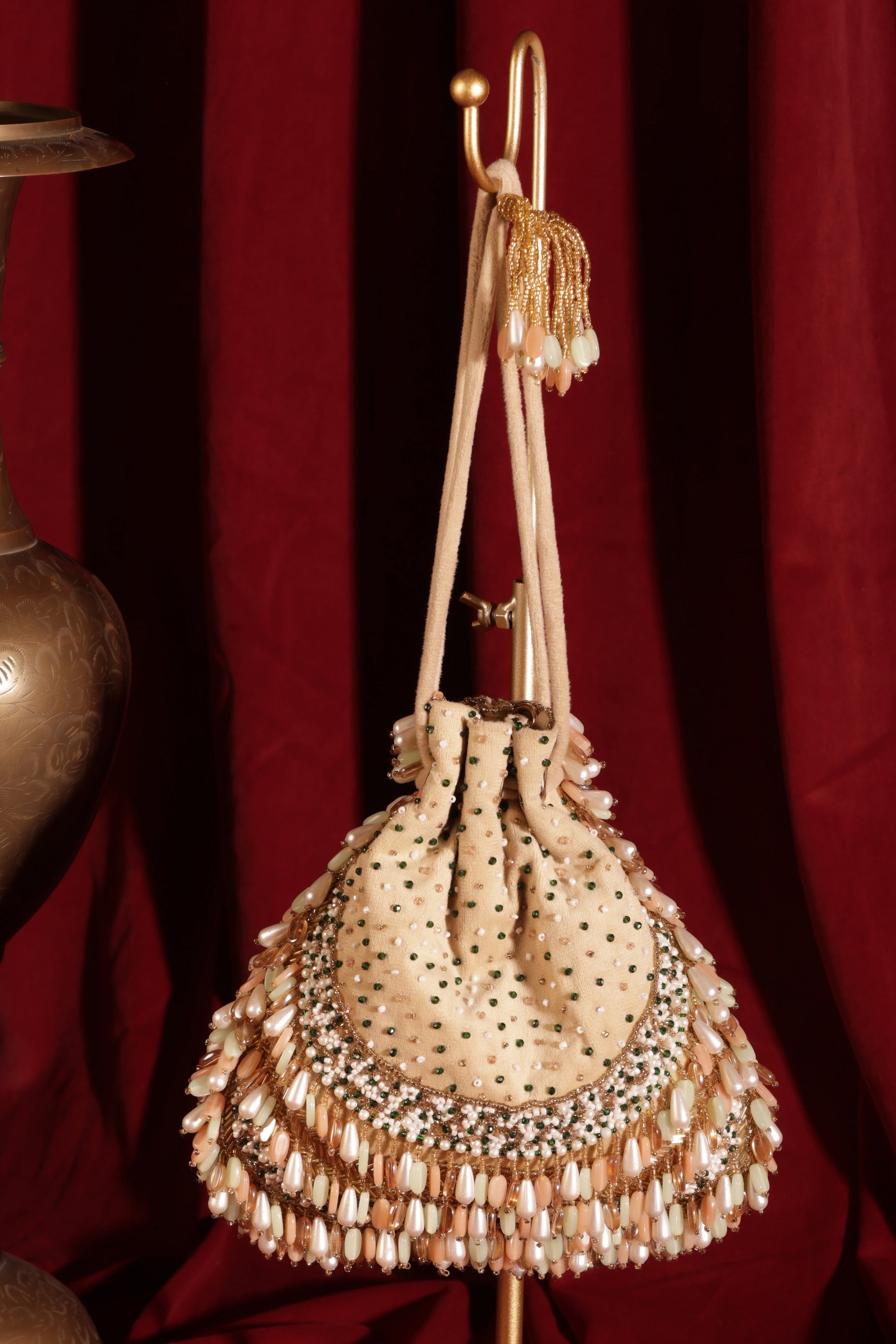 Off-white suede Tarang Potli with enamel stones and bead detailing, Meenakari-inspired potli bag for weddings.