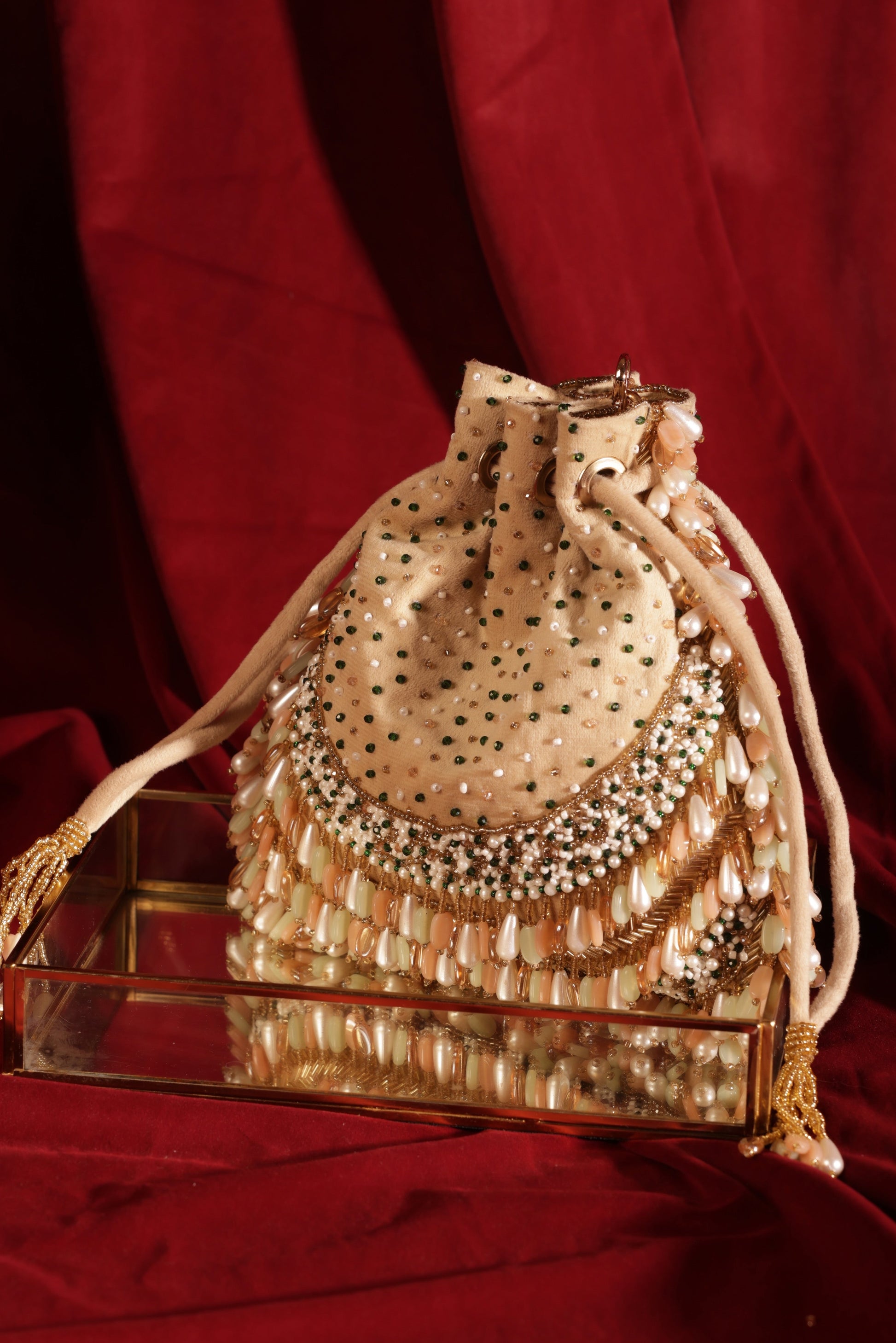 Handcrafted off-white potli with subtle Meenakari-style enamel work and beaded design.
