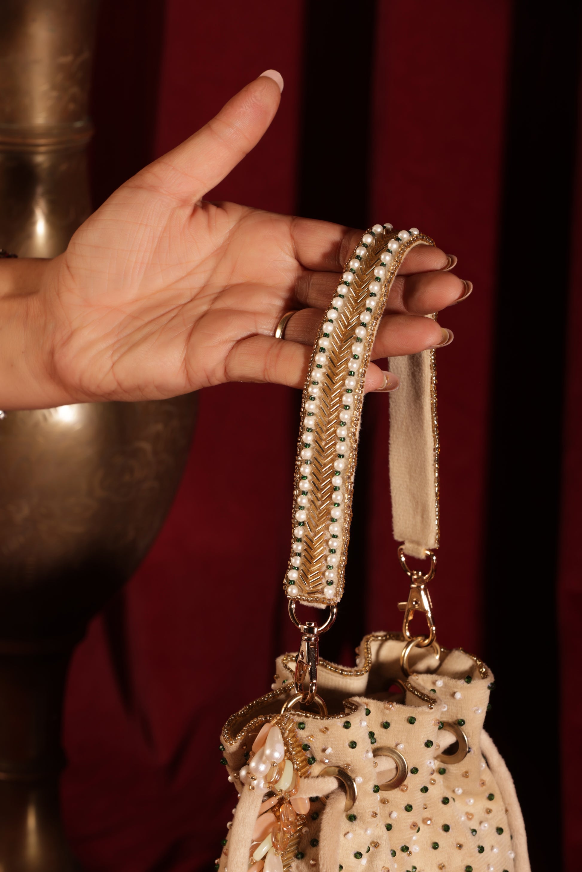 Designer off-white enamel stone potli with beaded accents, perfect for festive and bridal outfits.