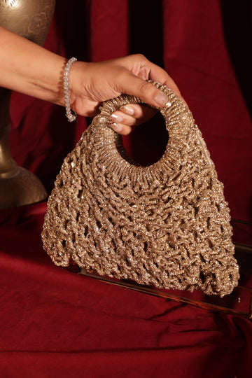 Glimora collection of mesh-work handbags in green, red, champagne, and gold with circular handles on a red backdrop.