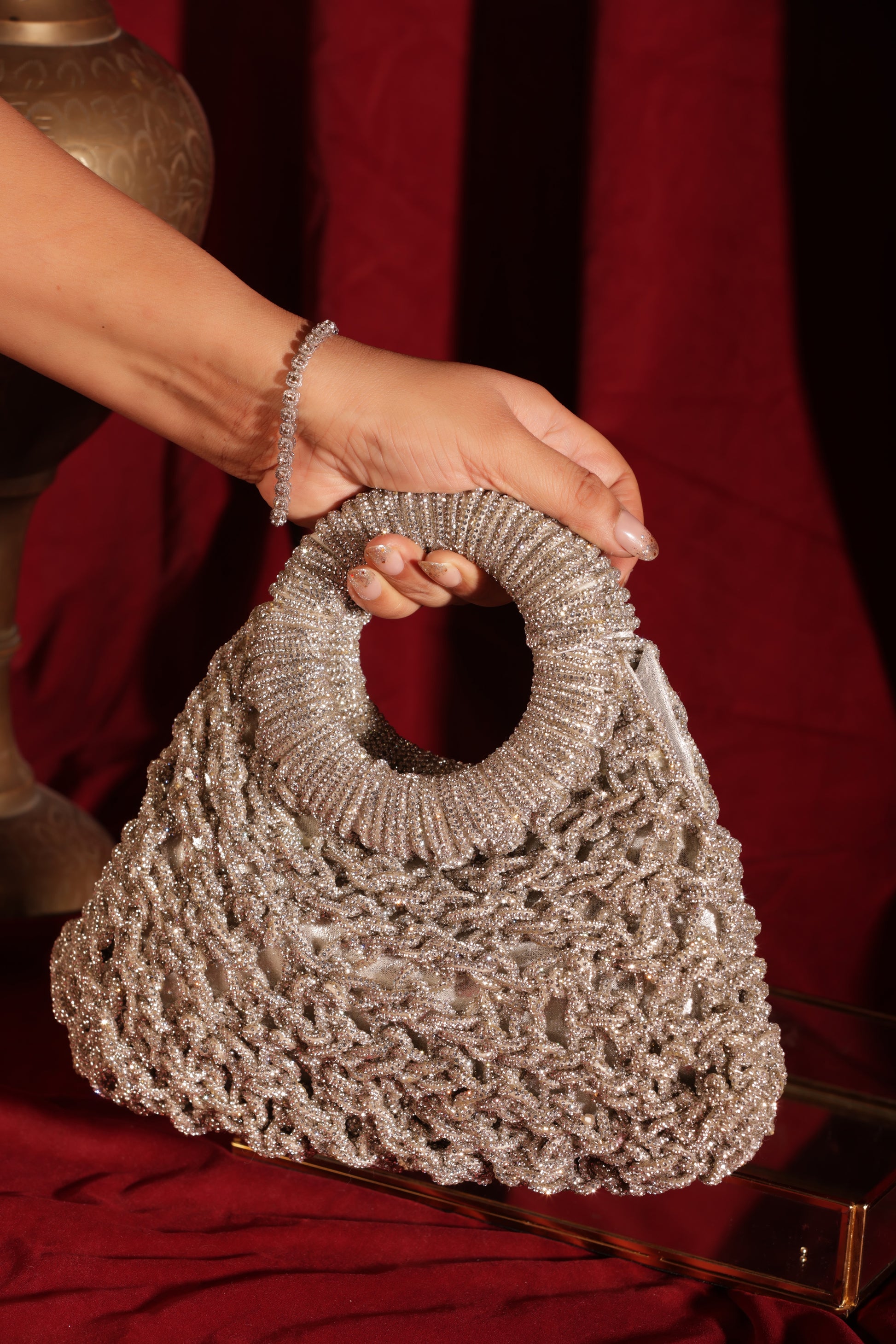 Luxury mesh-work crescent handbags in multiple colors with circular handles, perfect for weddings and festive styling.