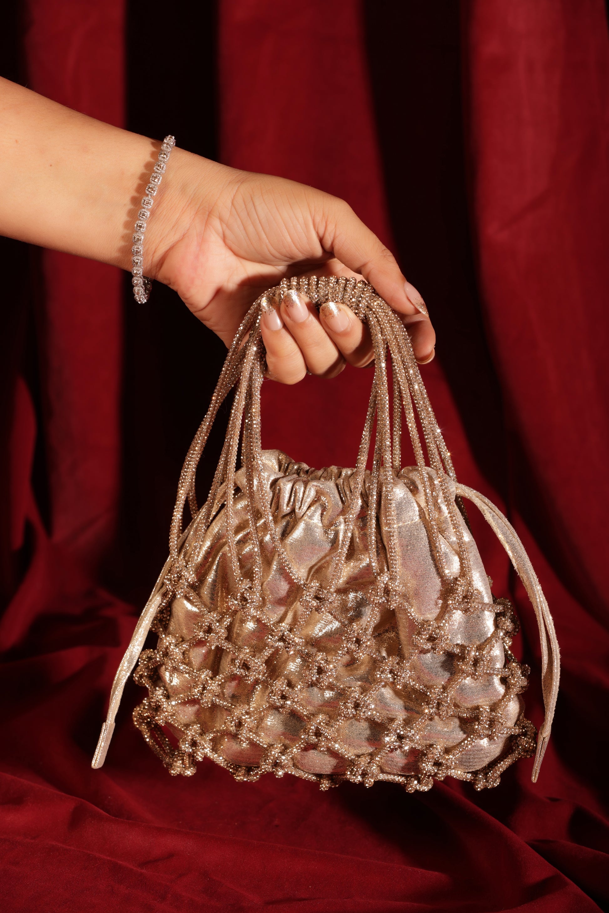 Designer golden potli with shimmer fabric and embellished net, perfect for weddings.