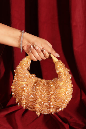 Gold crescent-shaped clutch with shimmering crystals, ideal for bridal, festive, and party outfits.