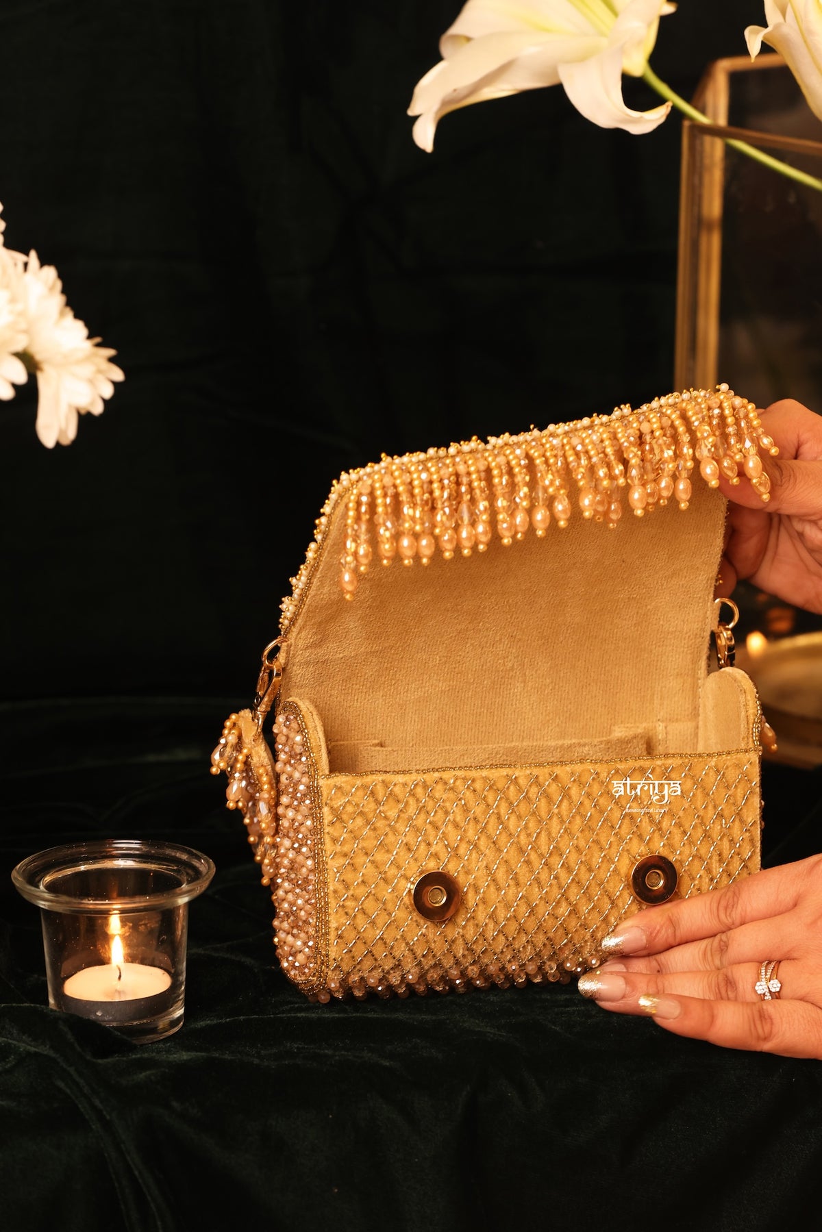Close-up of intricate hand-embroidered floral mirrors and beads on luxury bridal clutch
