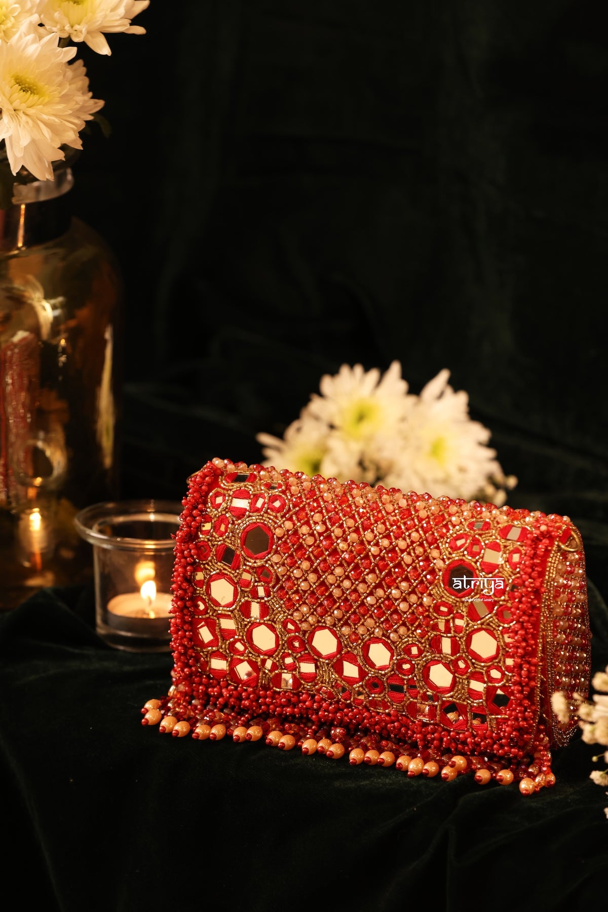 Close-up of artisan hand-embroidered floral mirrors, glass beadwork, and cascading fringe on bridal clutch