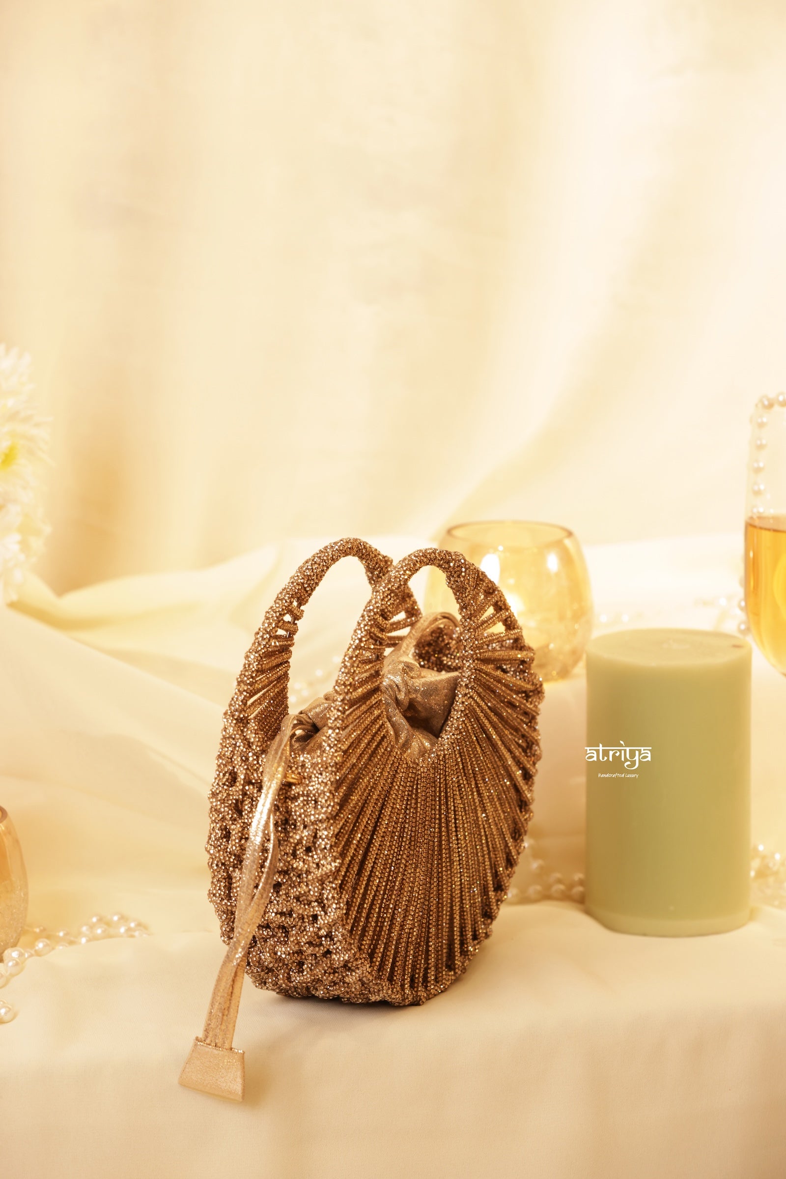 Close up of radiating golden crystal strands and circular structured frame on Stardust Gold Luxe clutch