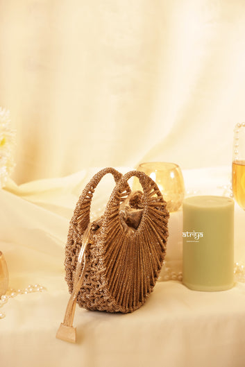Close up of radiating golden crystal strands and circular structured frame on Stardust Gold Luxe clutch
