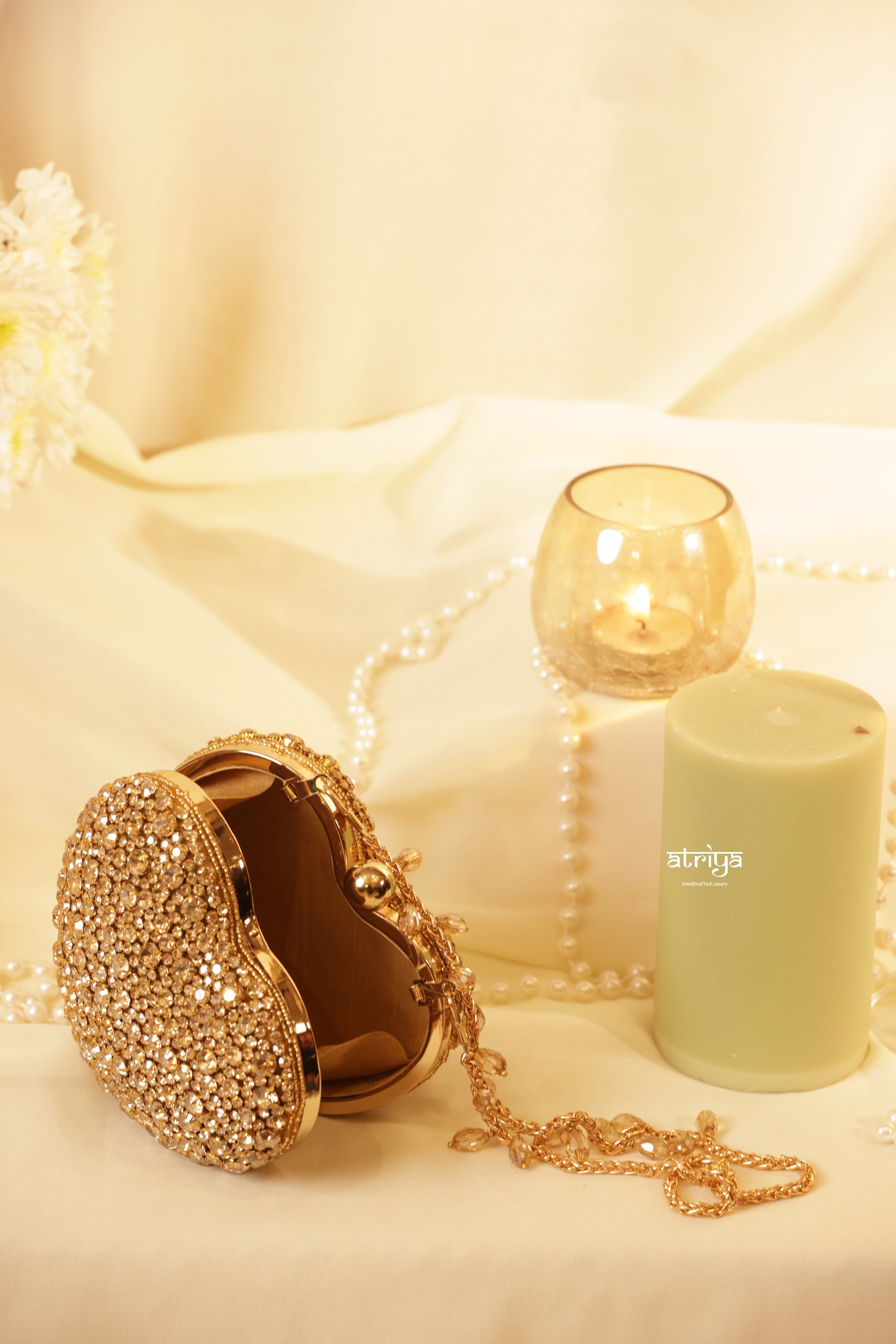 Heartbreaker gold stone clutch purse by Atriya Jaipur, a statement heart-shaped designer box clutch for women. Premium handcrafted metallic evening purse with gold chain, ideal accessory for modern bridal wear, luxury gifting, and reception parties.