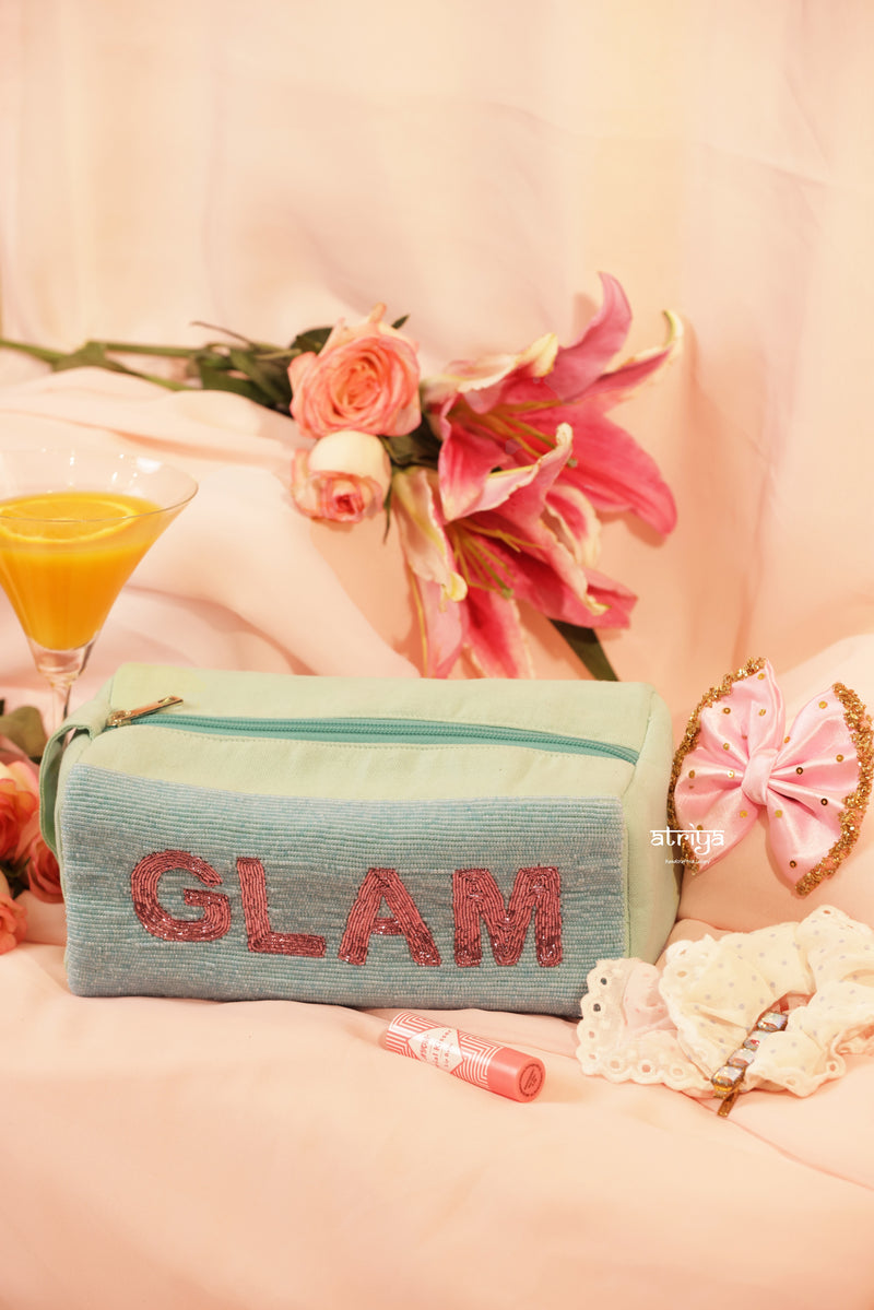 Pastel mint green handcrafted makeup kit with pink beaded GLAM embroidery, styled with satin bows and pink florals for Atriya Jaipur luxury collection.