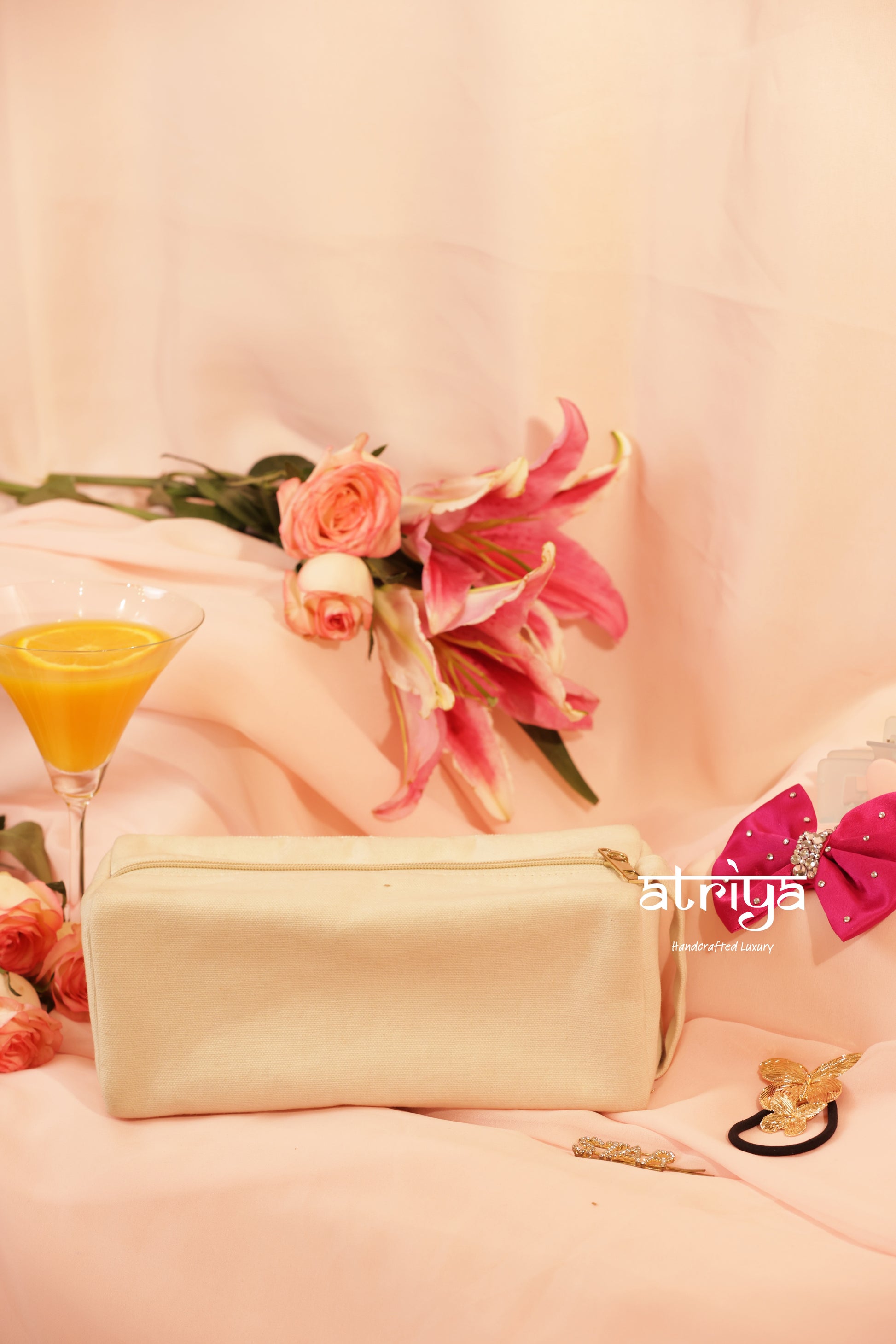 Premium beadwork pouch with GIRL POWER embroidery in pink on cream base, feminine editorial product photography for Atriya Jaipur Beauty Kits collection.

