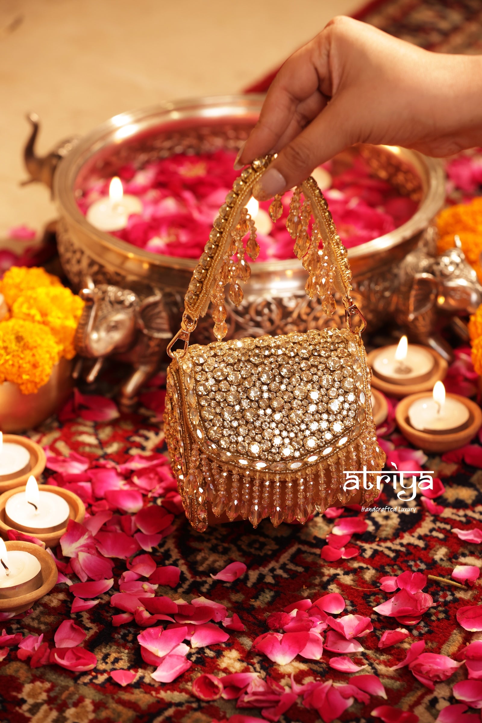 Goldette luxury gold kundan clutch displayed on traditional rug with diya candles and rose petals
