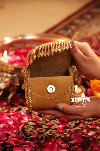 Close up of dense faceted crystal stones and gold kundan border embellishment on Goldette clutch