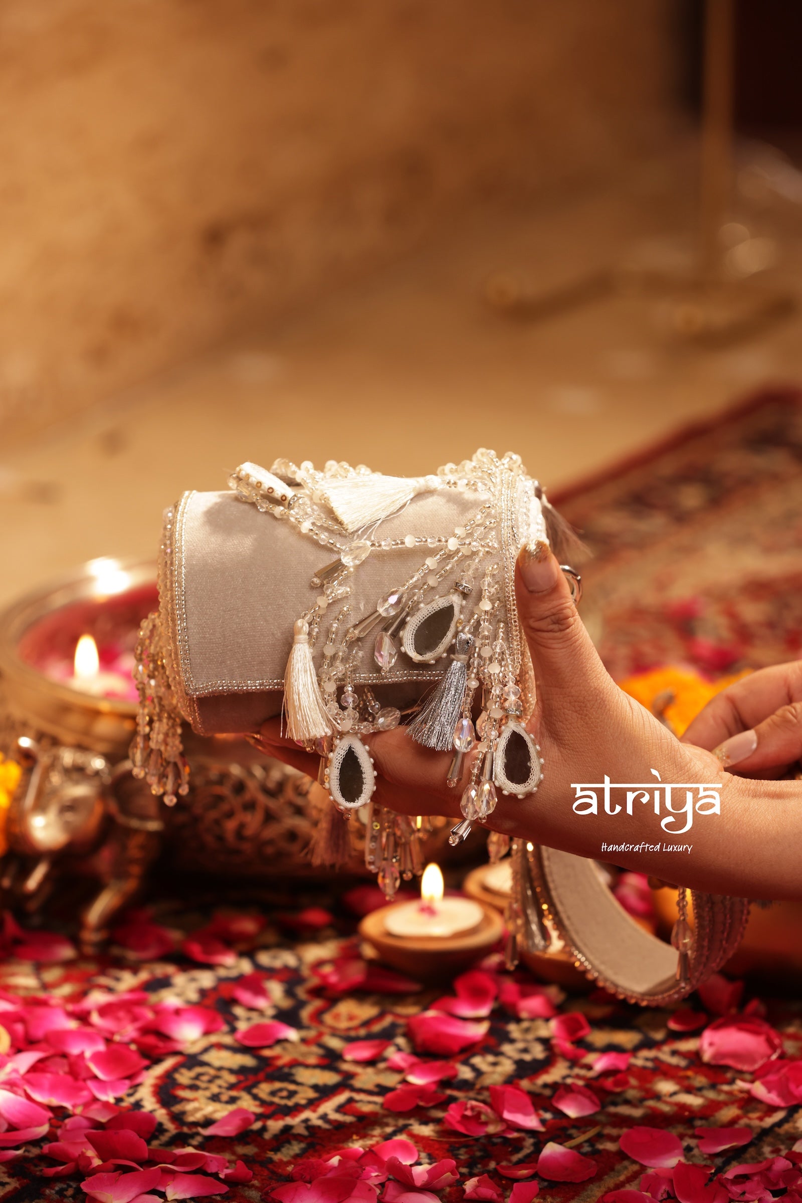 Close up of teardrop mirrors, cascading crystal strands, and metallic silver tassels on Noorani Silver structured bag