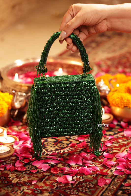 Close up detail of hand embroidered crystal beads and fluid side tassels on Inayat clutch