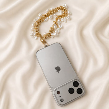 Close up of iridescent baroque pearls and textured gold links on Noor luxury phone wristlet charm